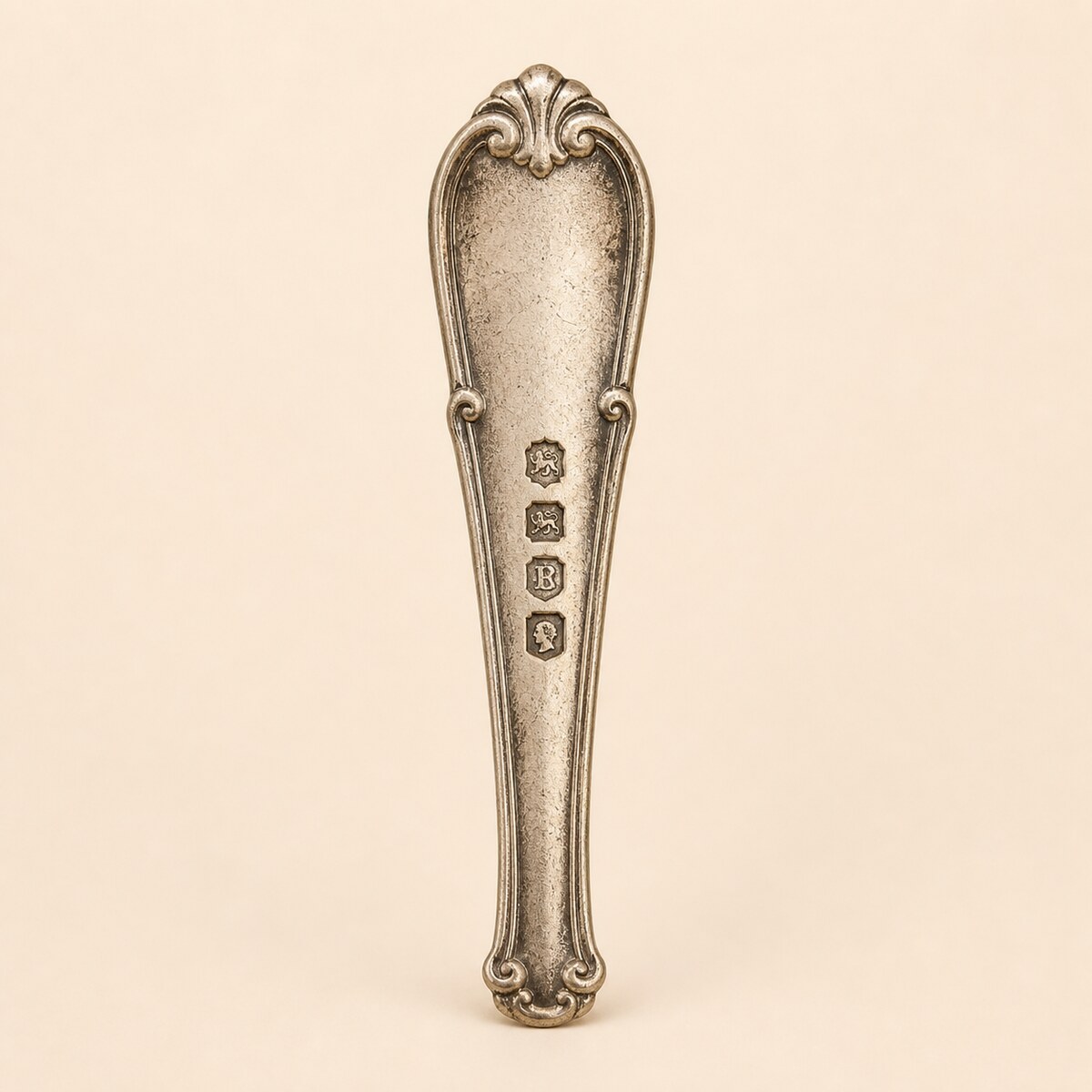 Row of stamped silver hallmarks on a polished silver surface